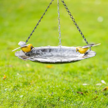 Metalen tuinbeeld van een voederschaal hangend geel, gemaakt door een Afrikaanse kunstenaar. 